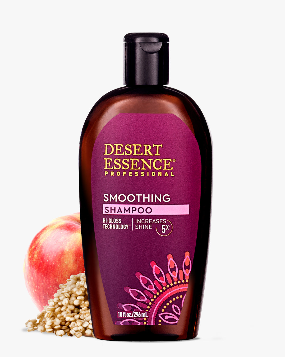 Desert Essence Smoothing Shampoo bottle with Hi-Gloss Technology displayed alongside fresh red apple and quinoa grains, featuring purple label with decorative mandala design and gold lettering on amber-colored bottle