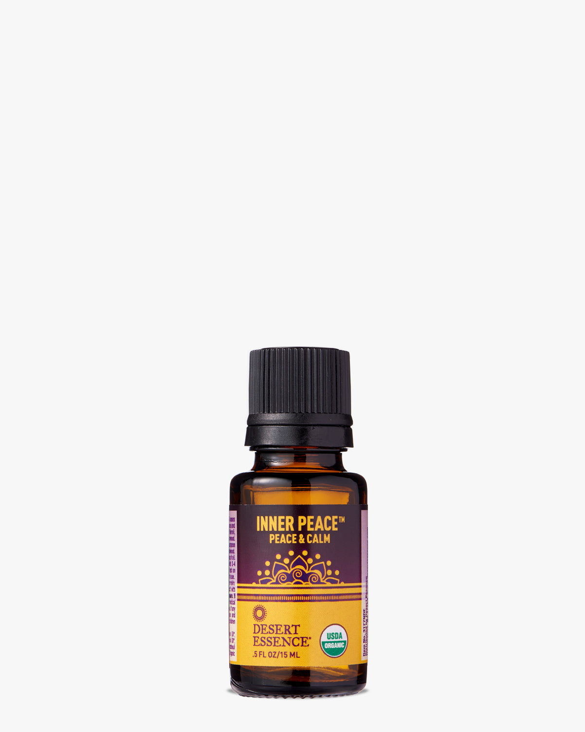 Inner Peace Organic Essential Oil in amber glass bottle with black cap, featuring purple label with golden mandala design. Desert Essence brand organic aromatherapy blend for relaxation and mindfulness.