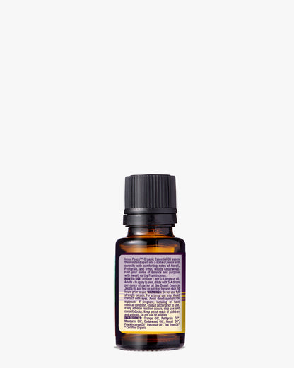 Inner Peace Organic Essential Oil in amber glass bottle with black cap, featuring a label with product information against white background. USDA organic blend of Neroli, Petitgrain, Cedarwood, Frankincense, and Sandalwood for meditation and relaxation.