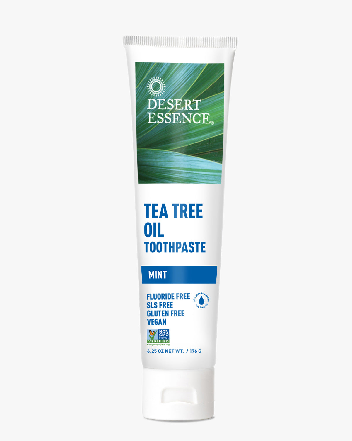 Desert Essence Tea Tree Oil Mint Toothpaste tube featuring a green palm leaf background and blue text, showcasing its natural, fluoride-free, vegan formula in white packaging with clear product labeling