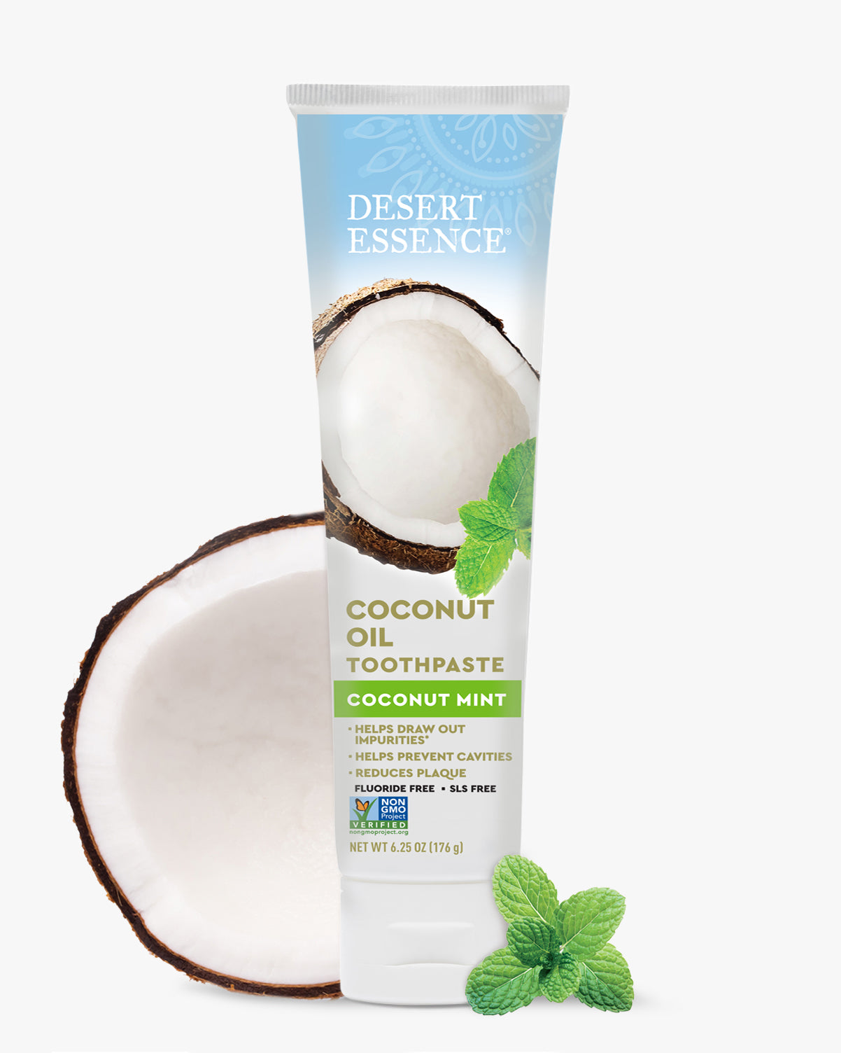 Desert Essence Coconut Oil Toothpaste with a coconut half and mint leaves on a white background