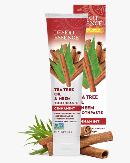 Desert Essence Tea Tree Oil & Neem Toothpaste with cinnamon sticks and leaves on a white background