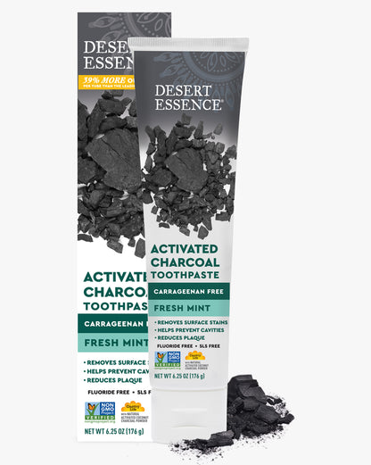 Desert Essence Activated Charcoal Toothpaste packaging with charcoal pieces on a white background