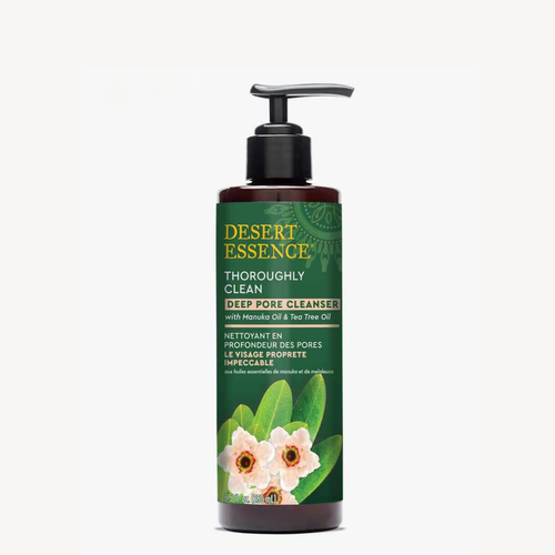Desert Essence Thoroughly Clean Deep Pore Cleanser bottle in dark brown with green label featuring delicate pink flowers and green leaves. NEW banner in red. Product features pump dispenser and bilingual text highlighting Manuka and Tea Tree Oil ingredients.