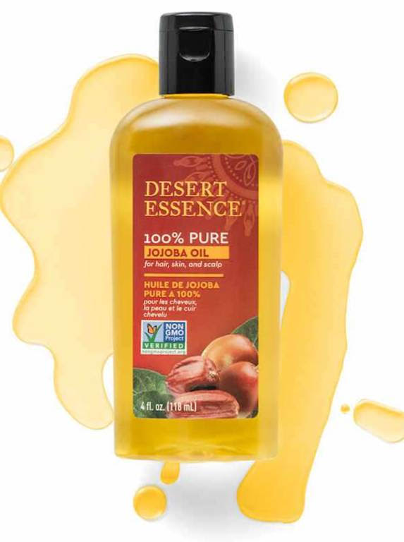Desert Essence 100% Pure Jojoba Oil bottle, B Corp certified, for hair, skin, scalp, with a non-GMO label on a vibrant yellow splash background