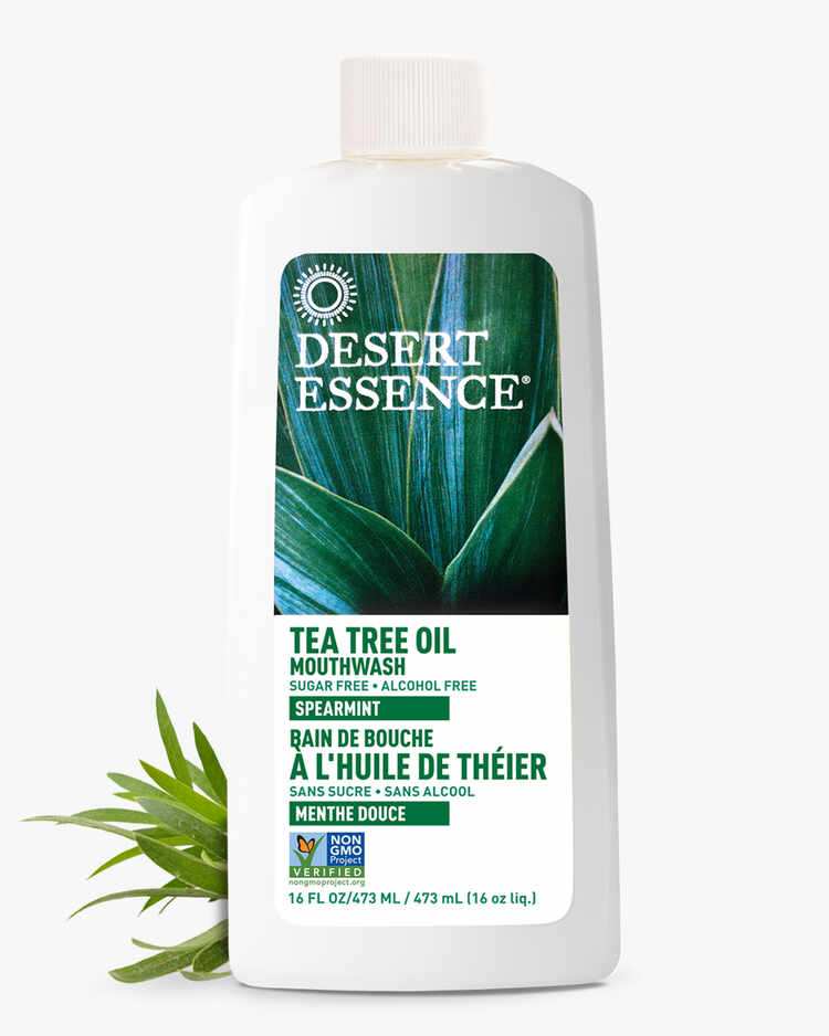 16 Fl. oz. bottle of the Tea Tree Oil Mouthwash Spearmint with spearmint leaves by Desert Essence.